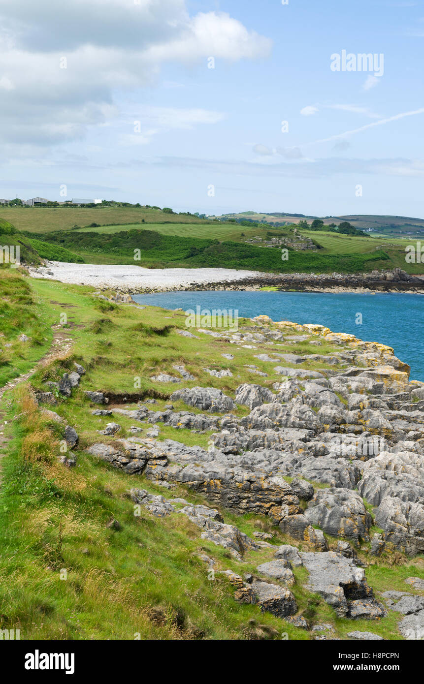 Spiaggia di sabbia e costa frastagliata lungo la Anglesey sentiero costiero vicino a Moelfre, Anglesey, Galles del Nord, Regno Unito Foto Stock