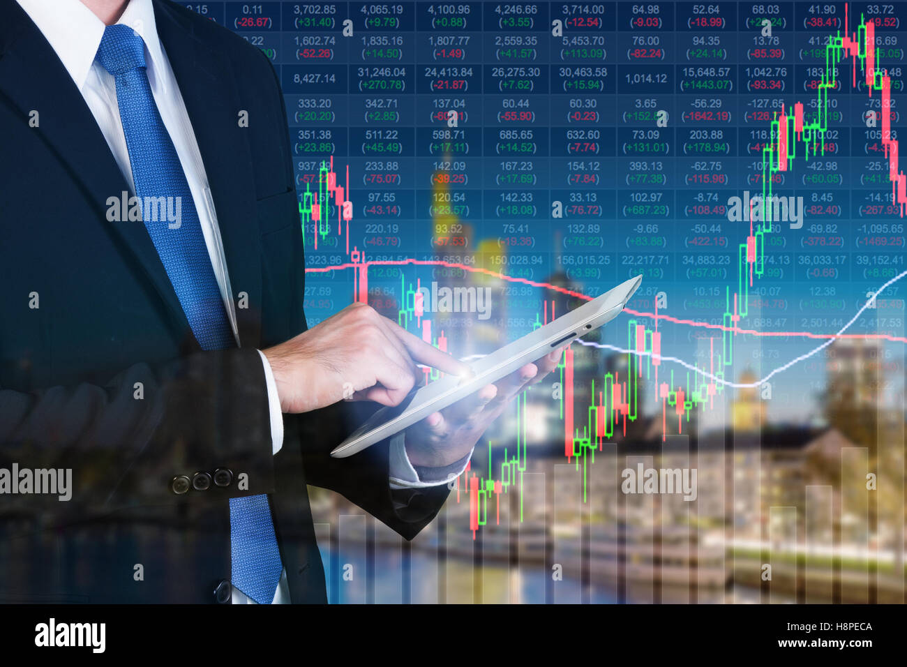 Imprenditore con tavoletta digitale lavora con il mercato azionario nel grafico sullo schermo del computer oltre il mercato azionario exchange su Francoforte Foto Stock