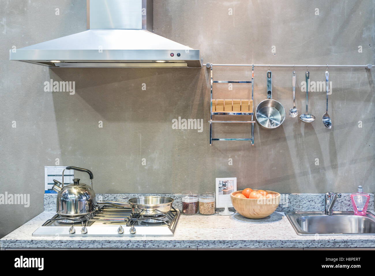 Interno della cucina con cappa, fornello a gas snd lavello a casa. Apparecchio di moderna cucina. Foto Stock