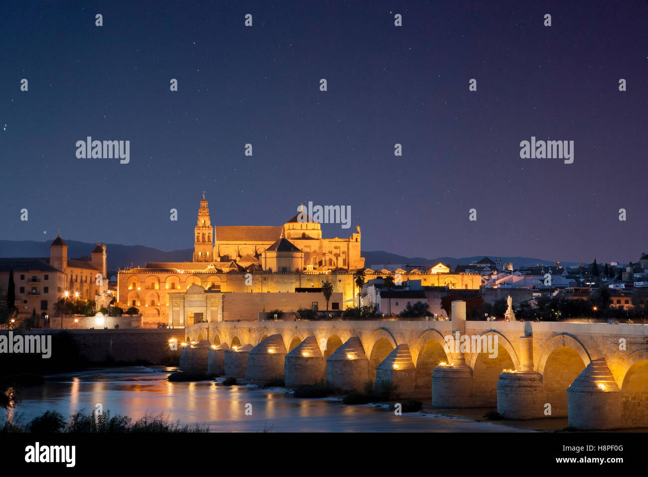 Ponte romano e la Moschea di Cordova sotto star-riempito il cielo, Cordoba, Spagna. Scena notturna Foto Stock