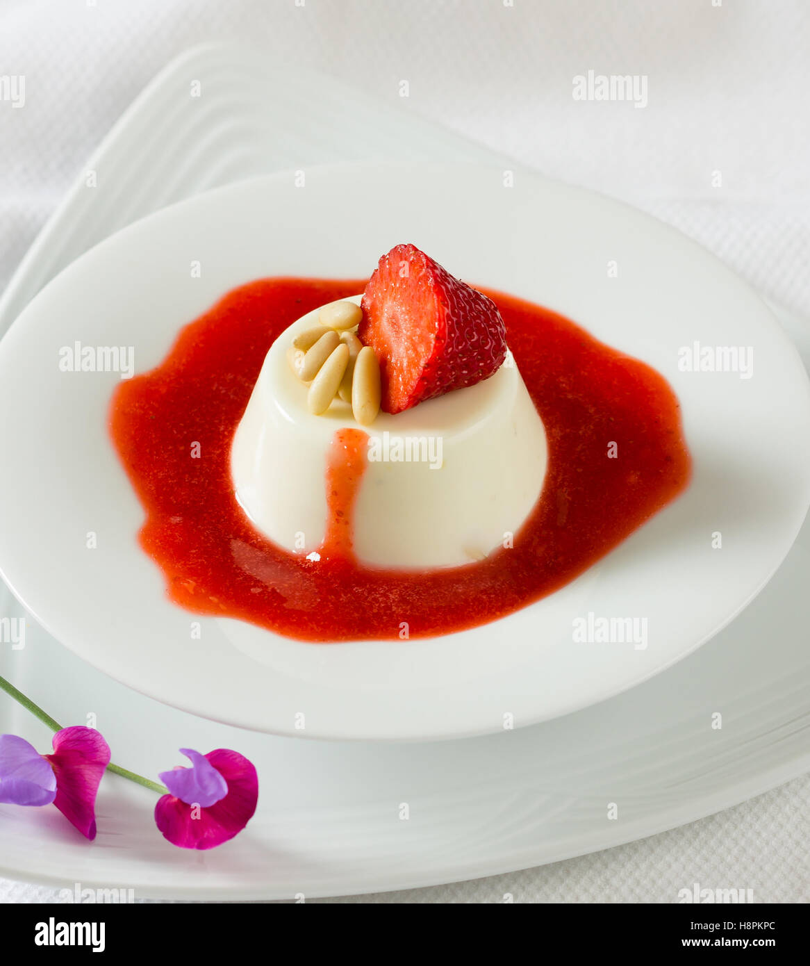 L'italiano panna cotta dessert con sciroppo di fragole e pinoli Foto Stock