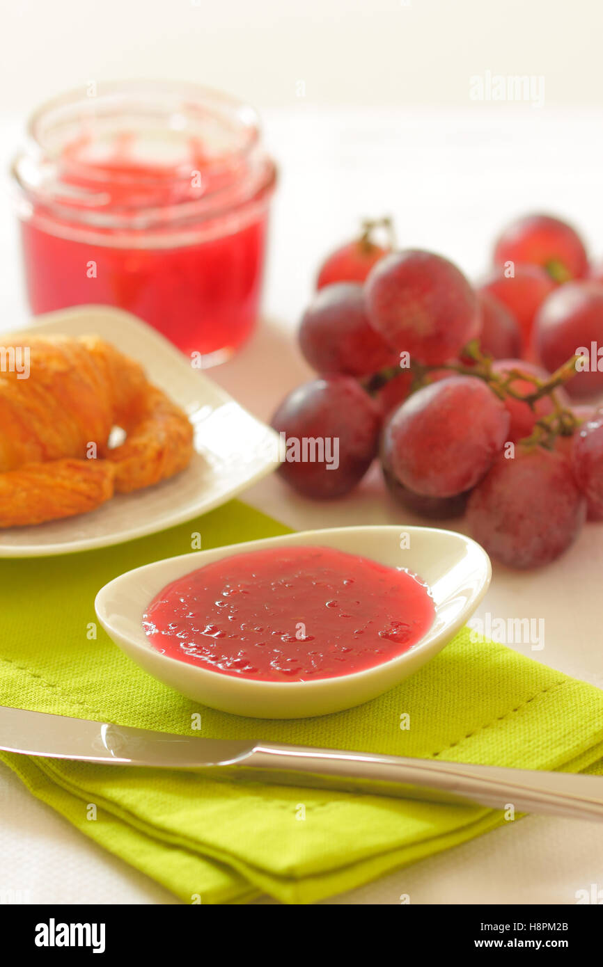 In casa chutney di uva delle uve rosse in un vaso di vetro su un tavolo per la colazione. Foto Stock