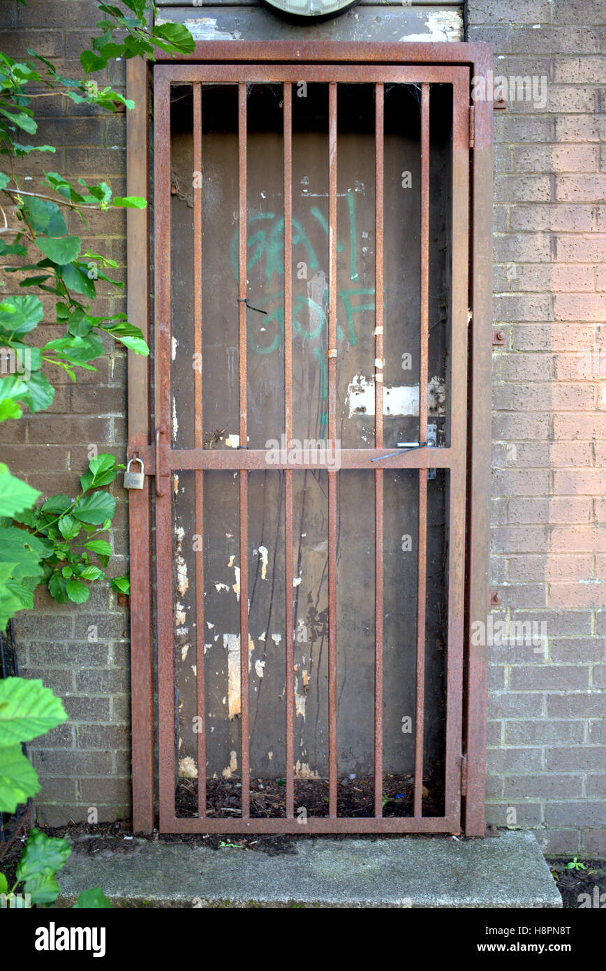 Le barre di blocco porta gate rosso griglia arrugginito un muro di mattoni Foto Stock