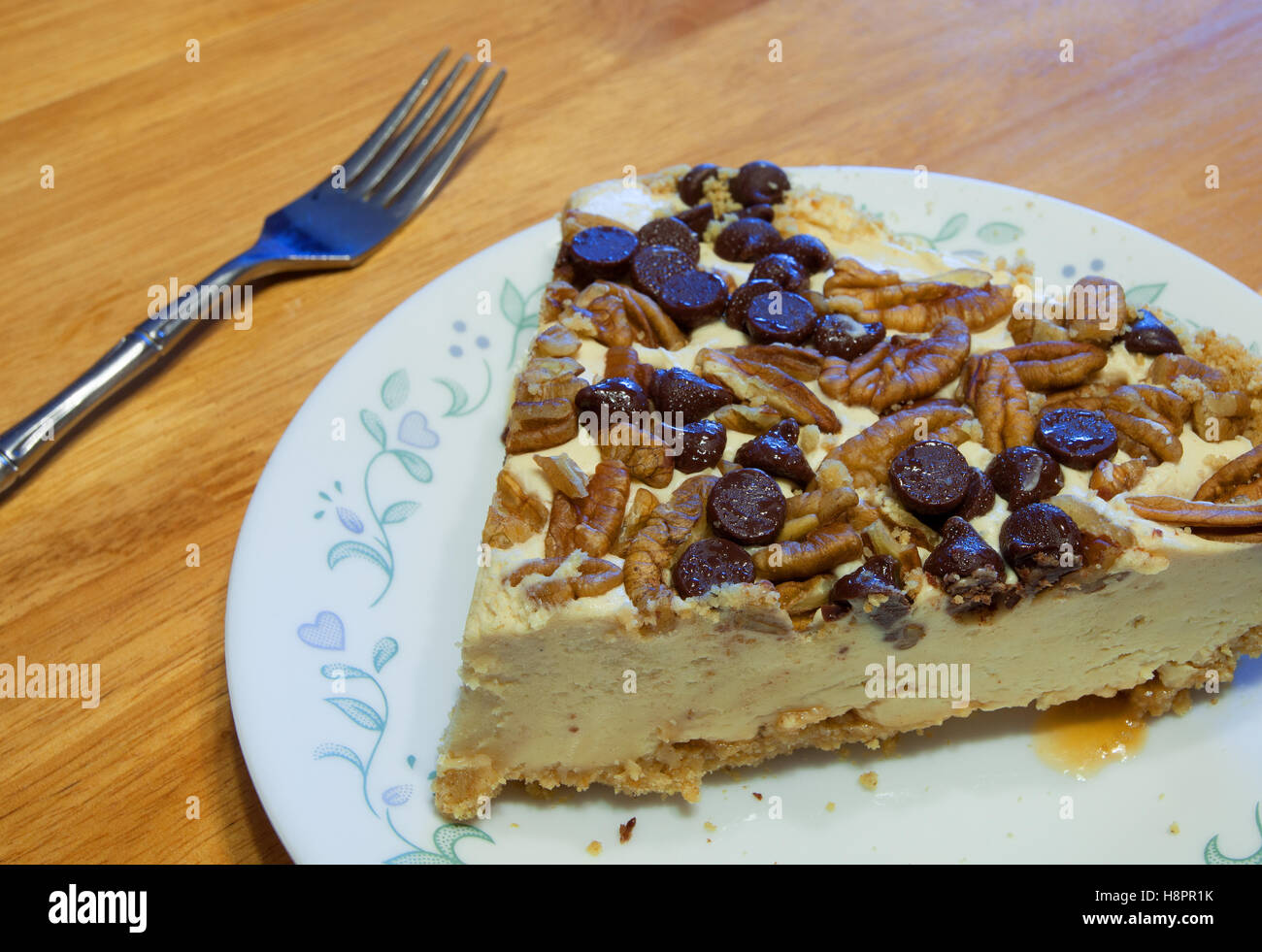 Grande fetta di cheesecake con dadi su una piastra Foto Stock