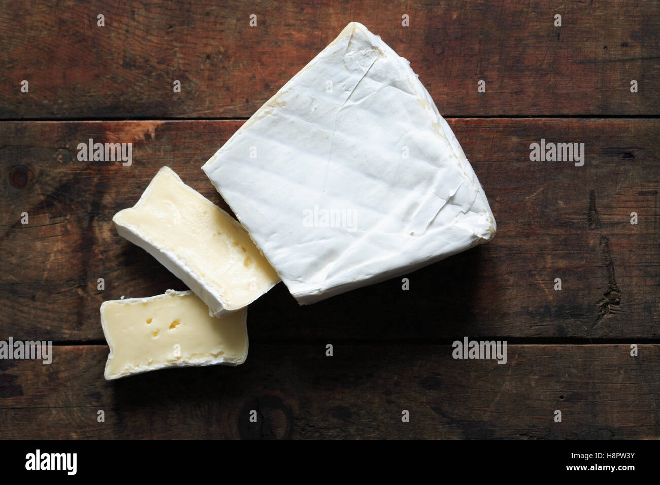 Pezzo di francese Formaggio Brie sul vecchio sfondo di legno Foto Stock