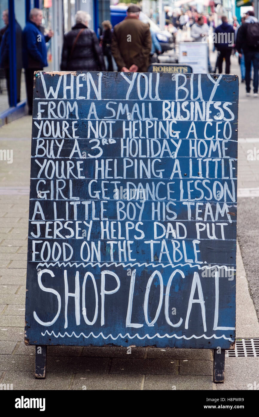 Blackboard firmare al di fuori di un locale di una macelleria incoraggiare gli acquirenti al negozio localmente. Caernarfon Gwynedd North Wales UK Gran Bretagna Foto Stock