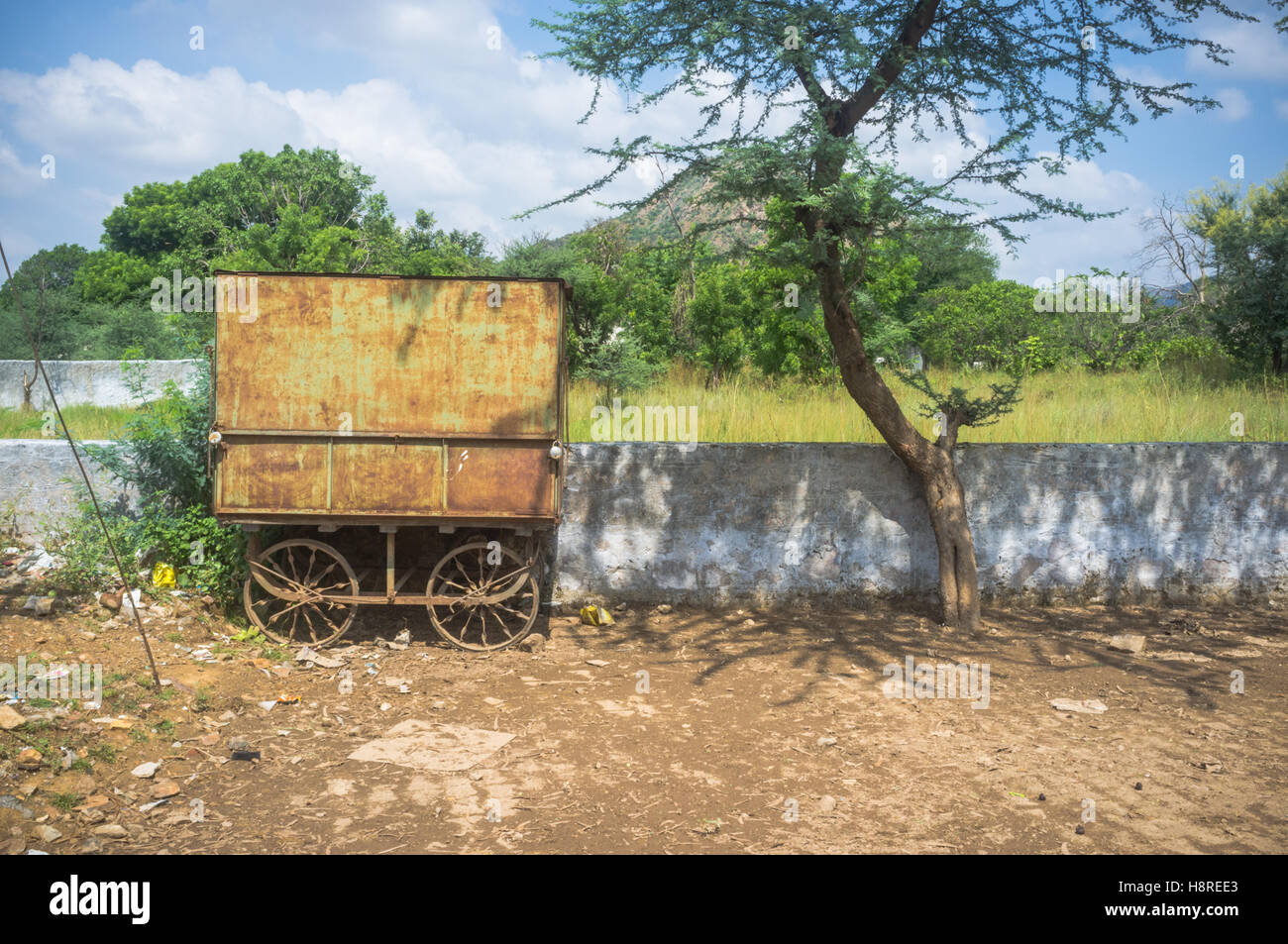 Vecchia quattro ruote di carro abbandonato sul ciglio della strada, Pushkar, Rajasthan, India Foto Stock