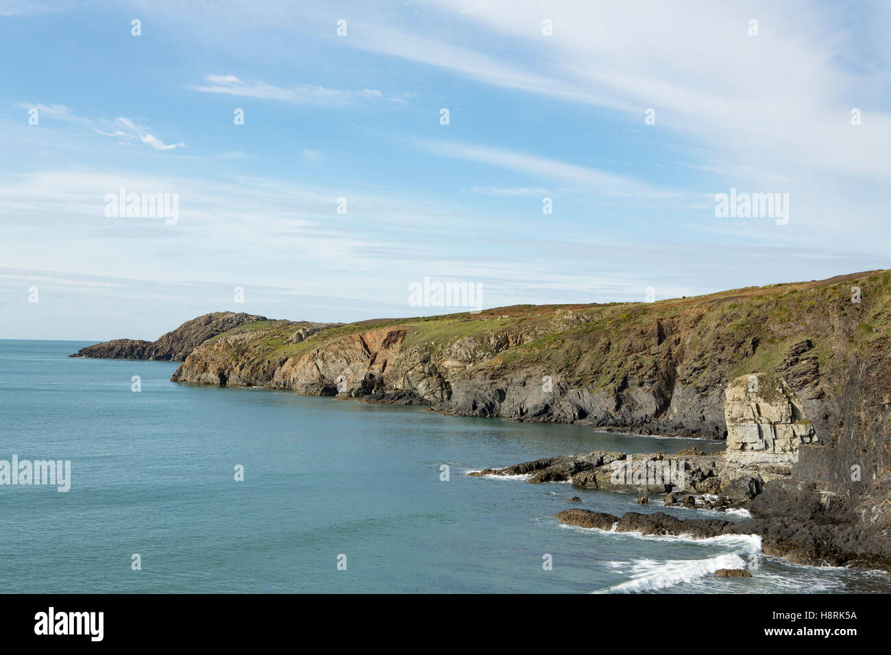 Robusto costa occidentale delle Isole Britanniche. Giornata di mare calmo con il blu del cielo e del mare con striature bianche del cloud. Foto Stock