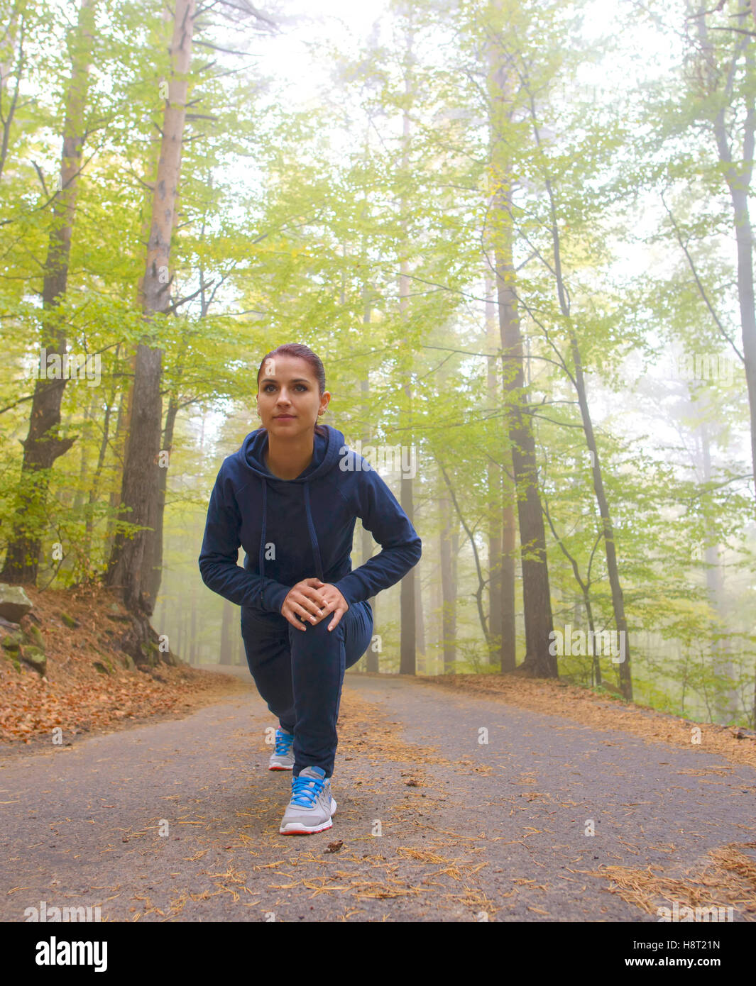 Energico giovane donna fare esercizi all'aperto nel parco per mantenere i loro corpi in forma Foto Stock