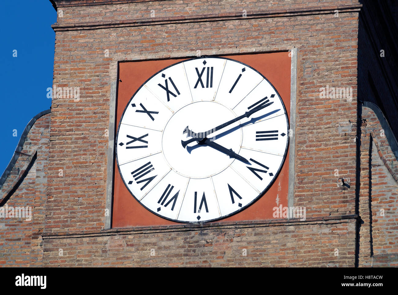 Clock Tower in un villaggio italiano di architettura romana con mattoni rossi Foto Stock