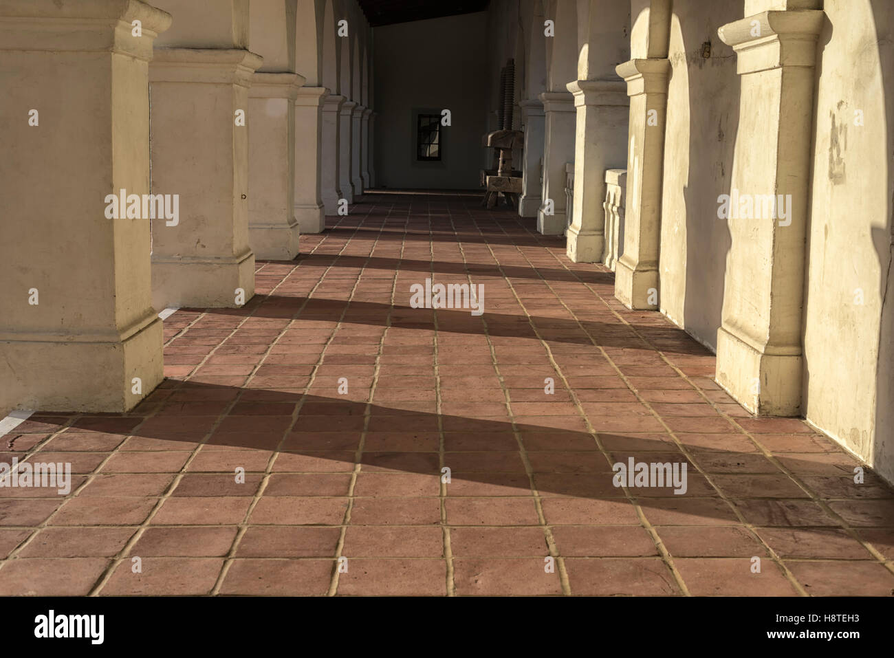 Camminamento lastricato, colonne, ombre. Foto Stock