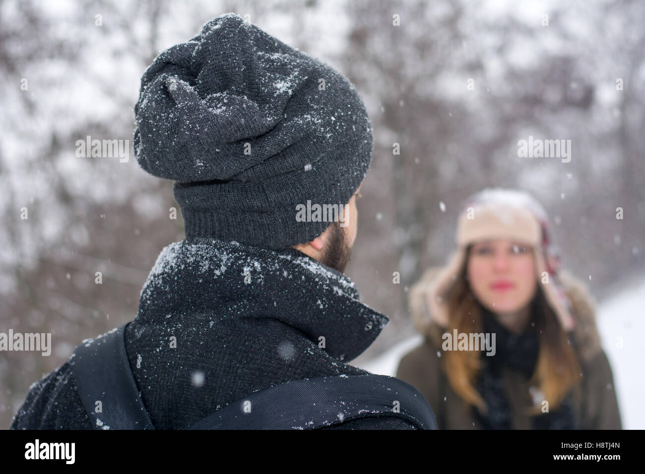 Giovane guardando gli uni con gli altri mentre nevica all'aperto Foto Stock