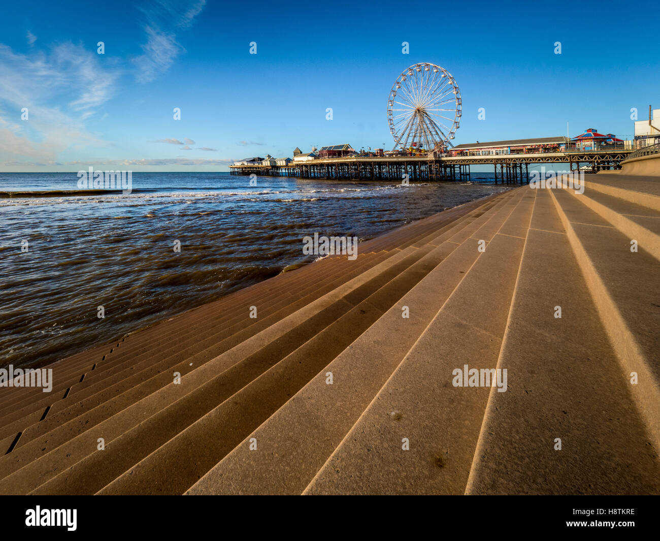 Central Pier e gradini in pietra che formano parte delle difese del mare, Blackpool, Lancashire, Regno Unito. Foto Stock