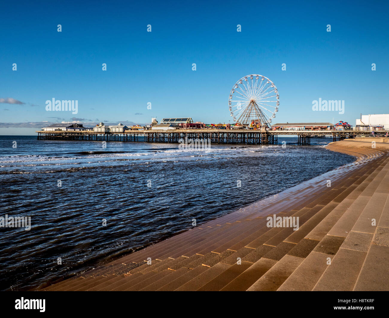 Central Pier e gradini in pietra che formano parte delle difese del mare, Blackpool, Lancashire, Regno Unito. Foto Stock