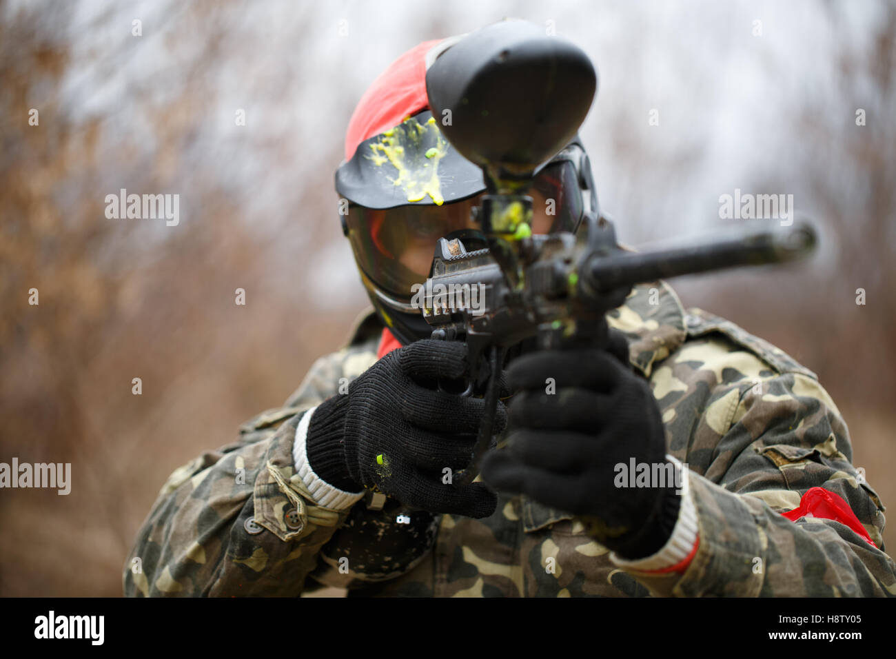 Paintball giocatore indossa la maschera protettiva e la pistola di puntamento Foto Stock