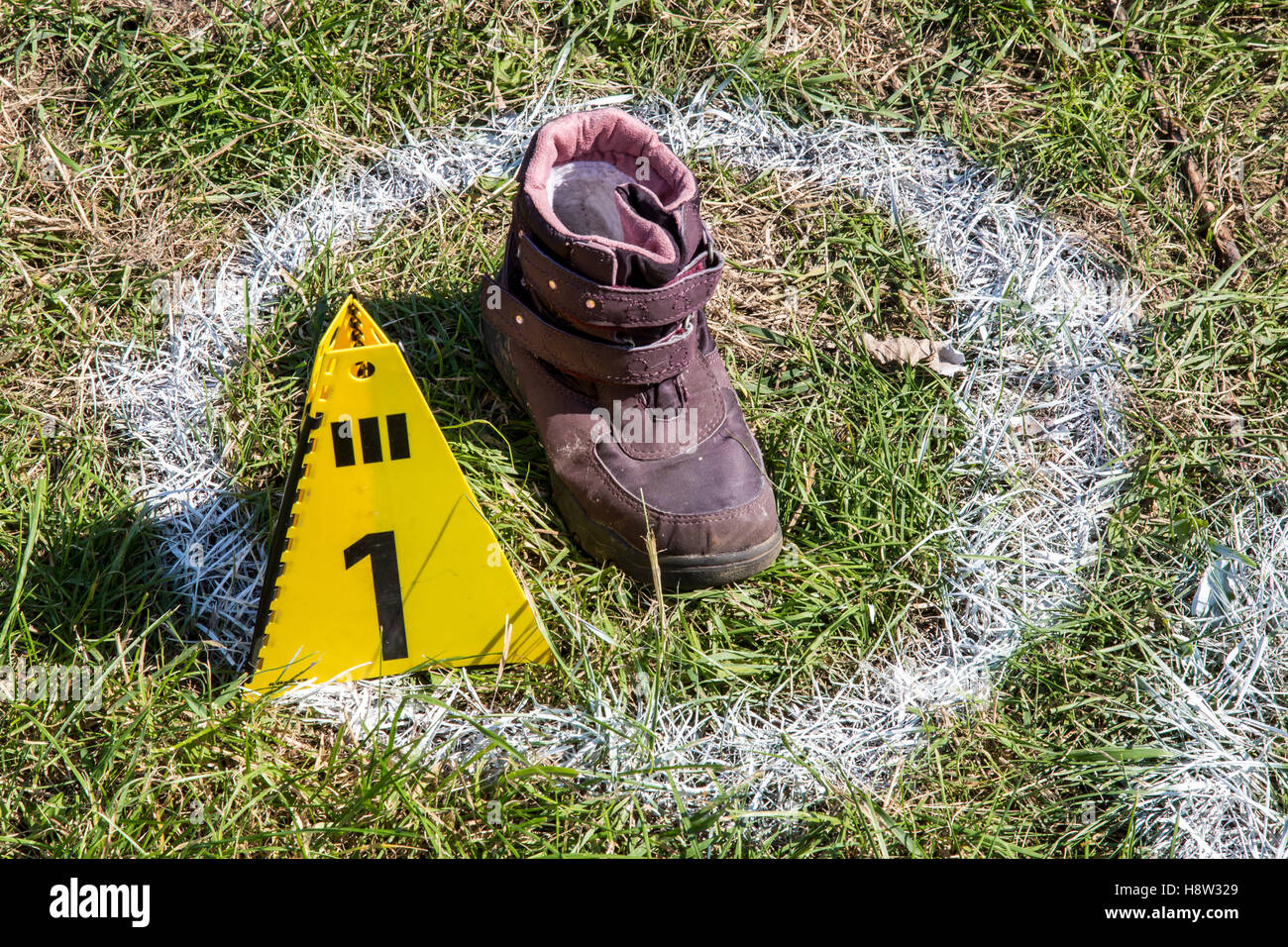 Spurensicherung, bei einem Unfall gefundener Schuh eines Opfers, markiert mit einer Spurentafel und einem weissen Sprühfarben Kr Foto Stock
