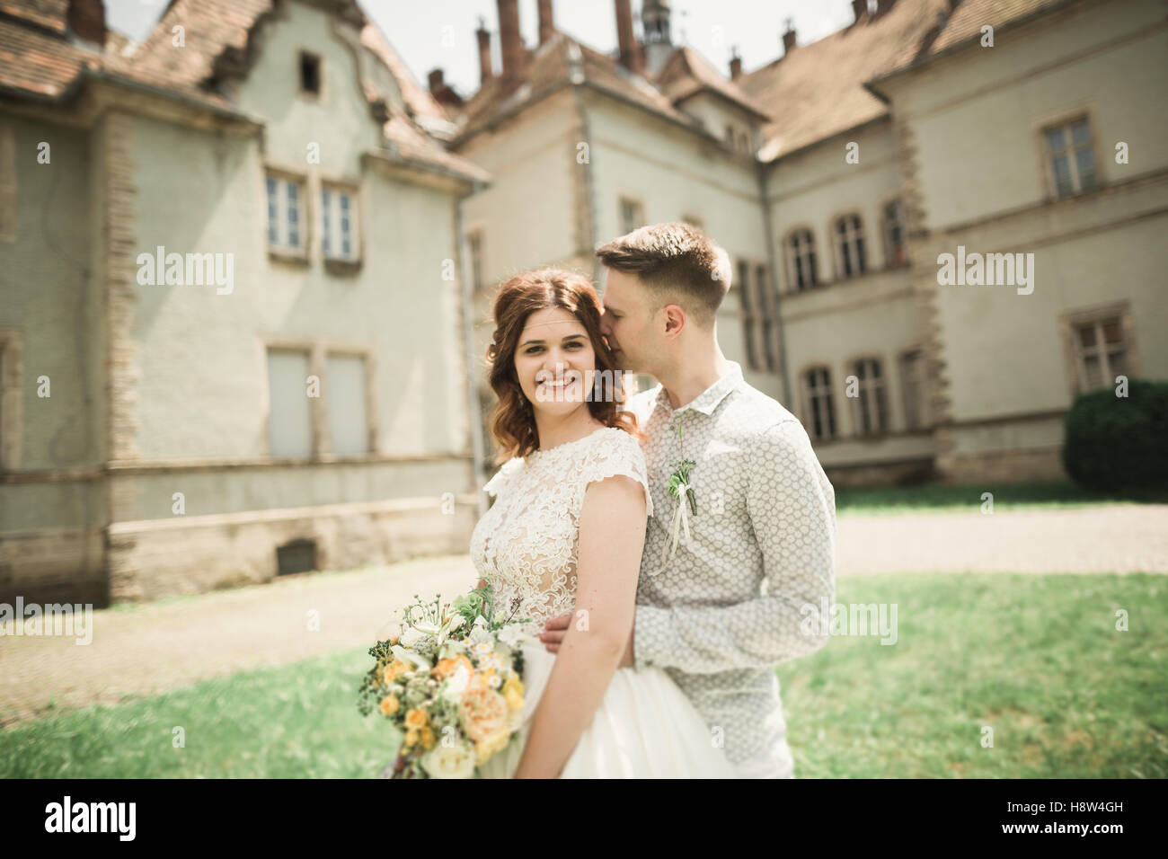 Bellissimo matrimonio romantico coppia di sposi novelli abbracciando vicino al vecchio castello Foto Stock