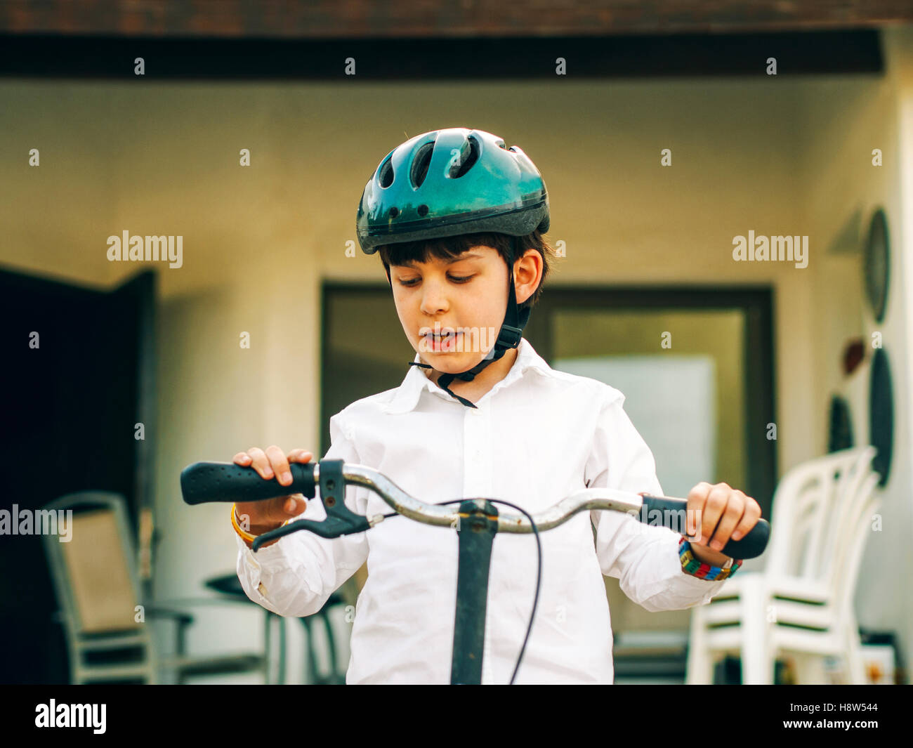 Giovane ragazzo indossa un casco mentre in sella alla sua bicicletta nel parco Foto Stock