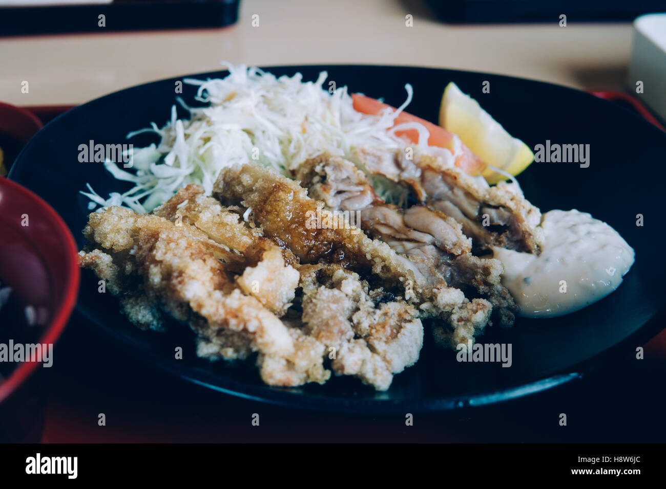 Stile giapponese piatto: Pollo fritto con insalata e zuppa di miso nel filtro retrò tanga effetto stilizzato Foto Stock