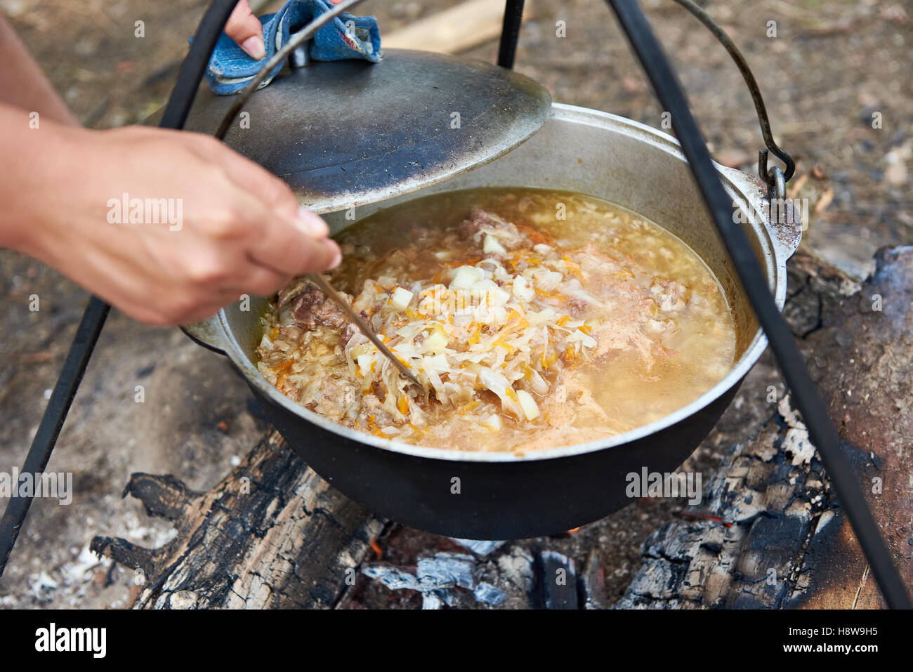 Cottura della zuppa cibo oltre a un falò in una escursione Foto Stock