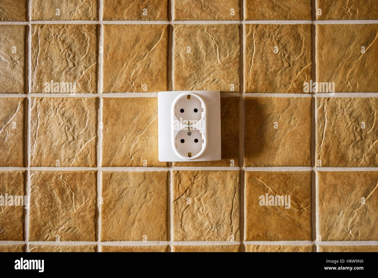 Bianco elettrico presa sulla parete della cucina con piastrelle di ceramica texture pattern Foto Stock