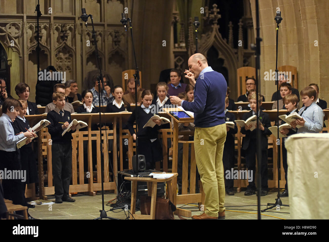 Coristi condotta dal maestro di coro a una sessione di registrazione per un CD commerciale produzione. Cattedrale di Wells scuola. Foto Stock