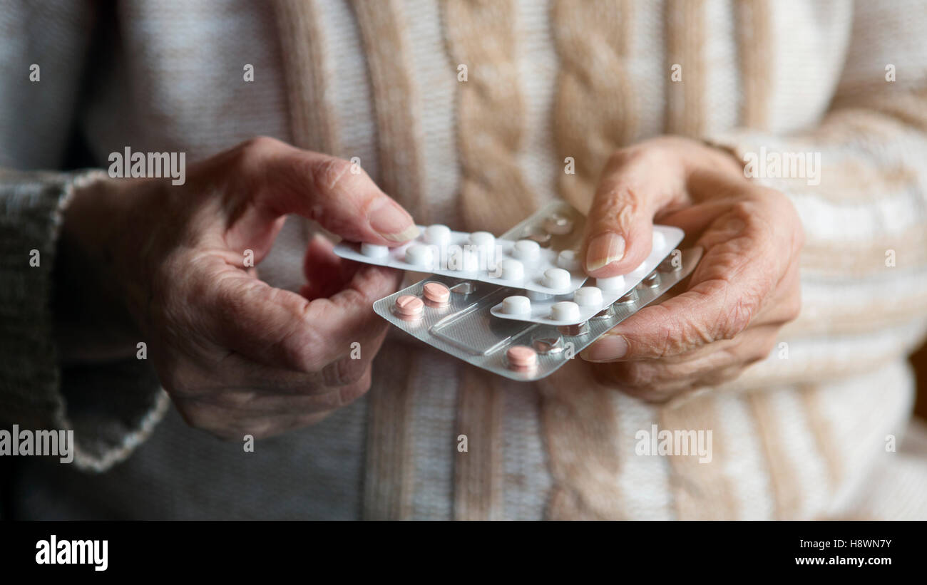 Vista dettagliata del vecchio mani femminili azienda pillole confezionato Foto Stock