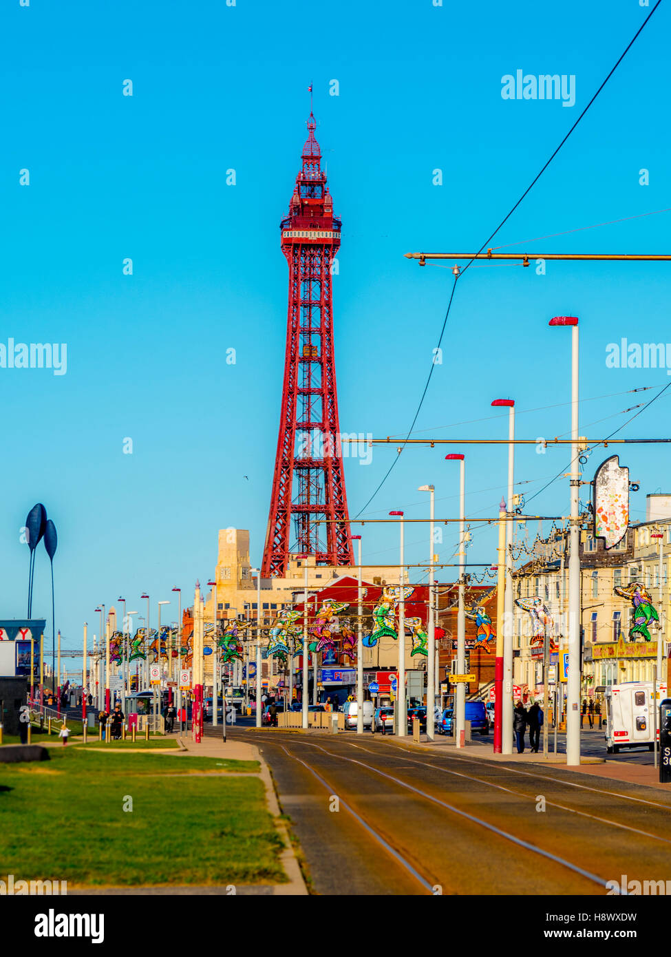 I binari del tram lungo la passeggiata sul lungomare con torre in distanza, Blackpool, Lancashire, Regno Unito. Foto Stock