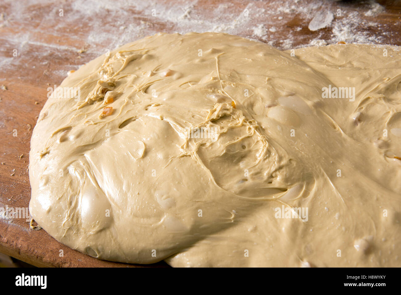 Cumulo di non cotti pasta soffice impasto su un tavolo infarinato in una pasticceria da forno o in una stretta fino ad alto angolo di visione Foto Stock