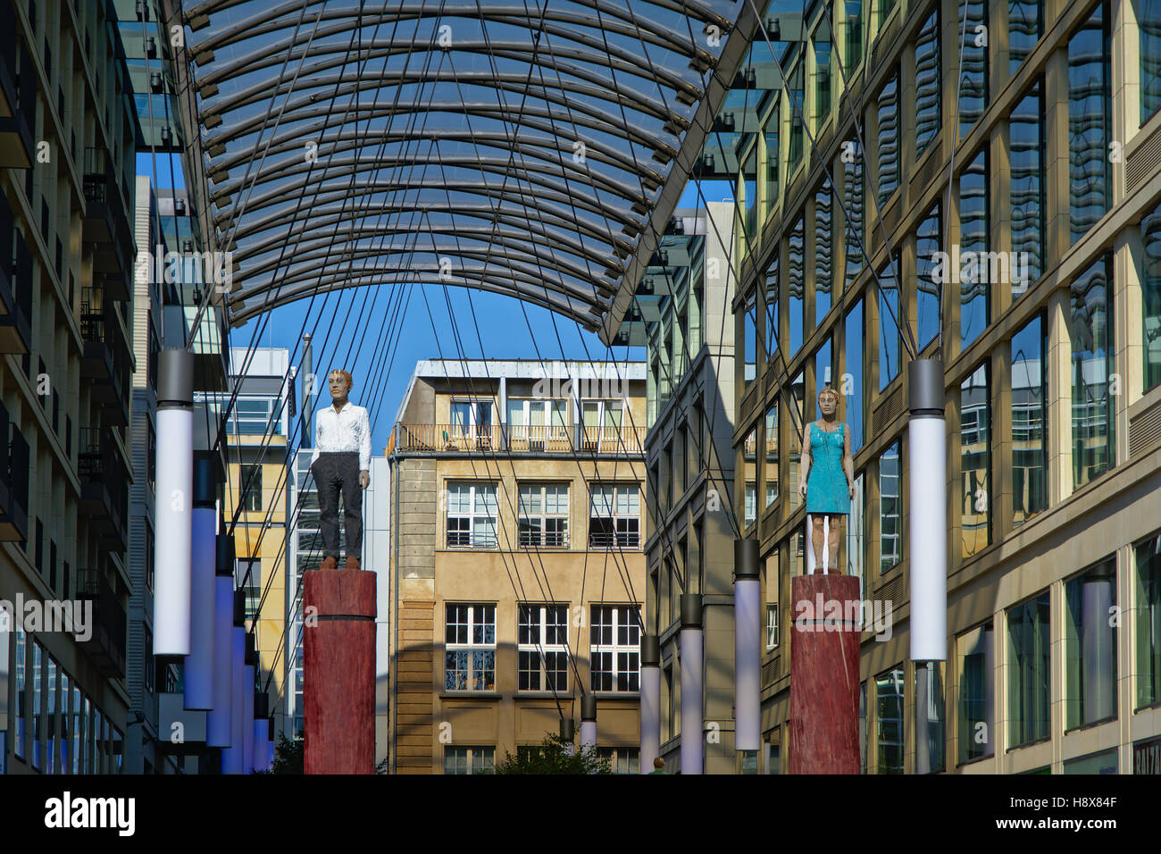 Dettaglio della coperta Heiligegeistkirchplatz passeggiata shopping a Berlino, con la statua di un uomo e di una donna Foto Stock