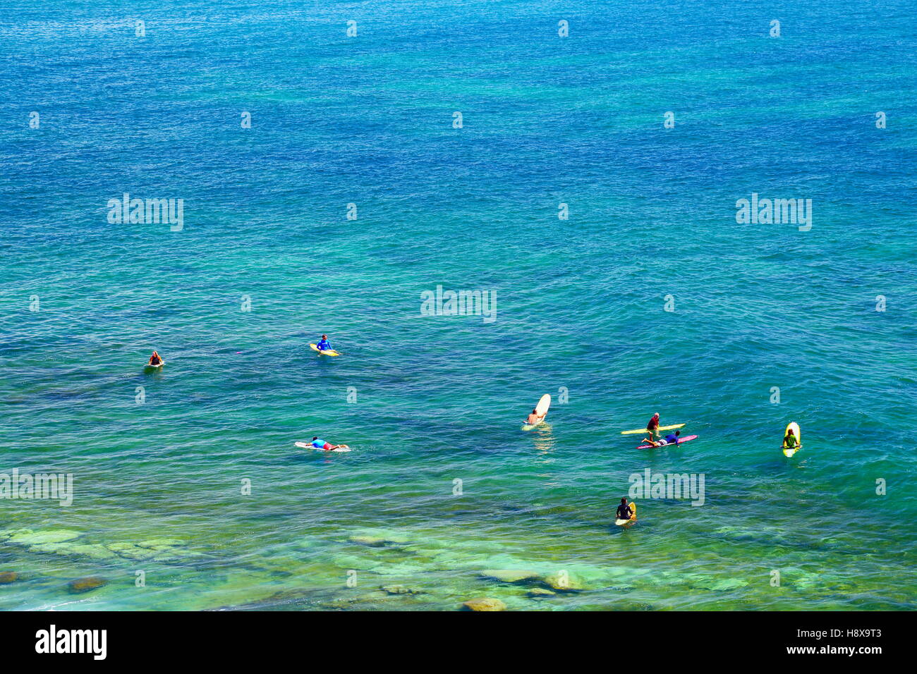 Otto persone sedersi sulle loro tavole da surf in acqua mentre navigano a Moffat Beach sulla Costa del Sole nel Queensland, in Australia. Foto Stock