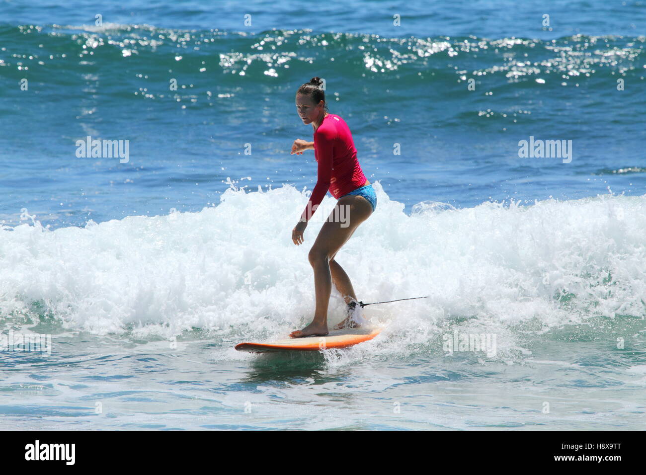 Una donna nel suo trenta surf un longboard a Moffat Beach sulla Costa del Sole nel Queensland, in Australia. Foto Stock