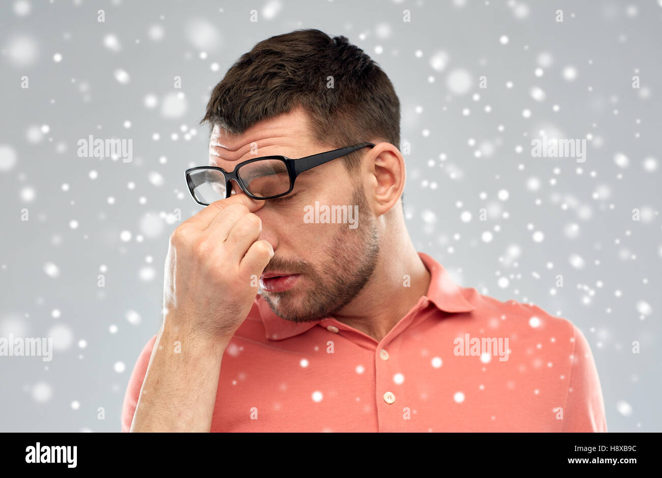 Stanco Uomo con occhiali di toccare il suo naso bridge Foto stock - Alamy