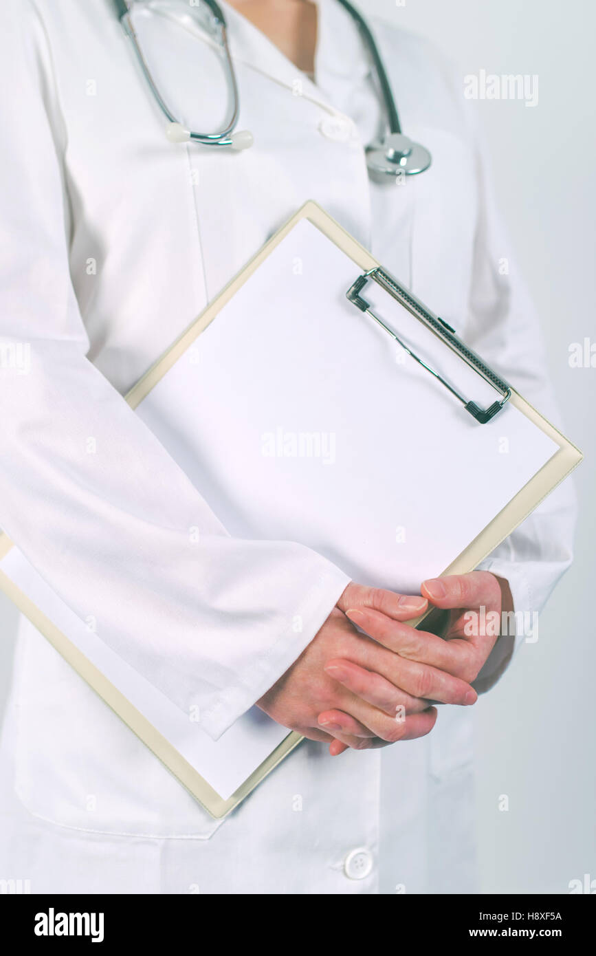 Medico donna in bianco uniforme in posa con vuoto pad appunti come copia di spazio per il testo o del paziente storia medica. La donna come specialista in medi Foto Stock