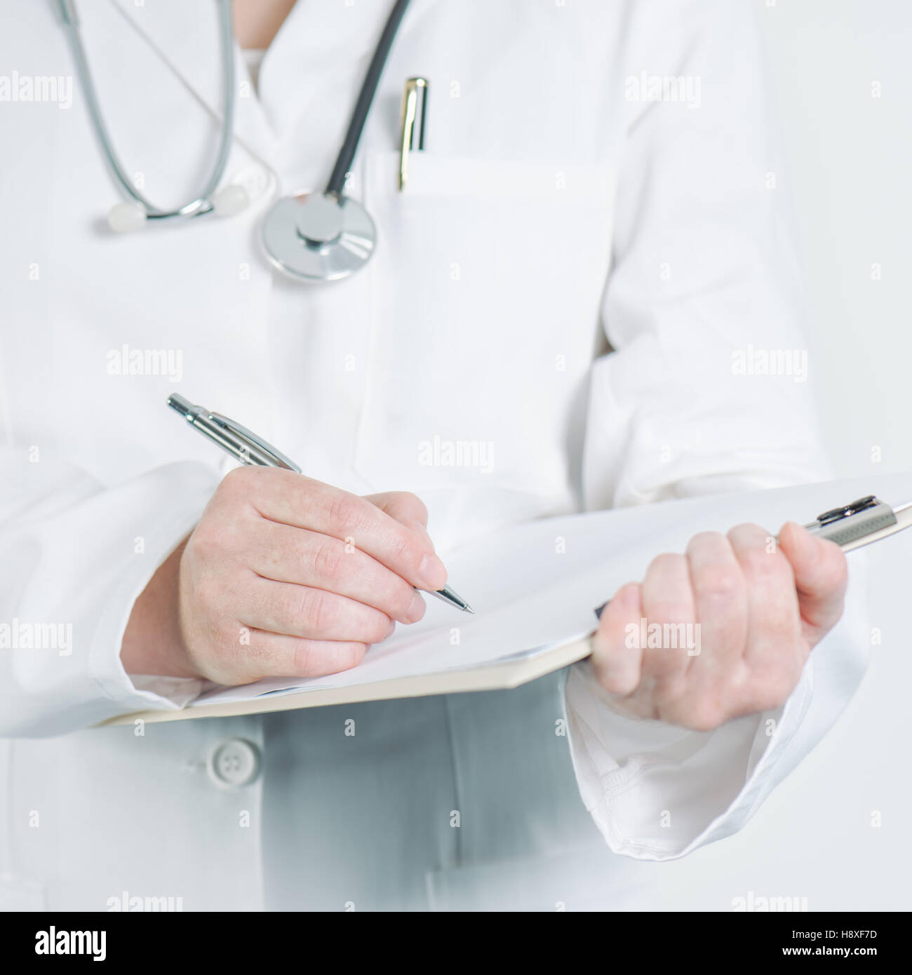 Medico donna scrivere appunti sul quaderno carta bianca consulenza medica, avviso, raccomandazione o suggerimento. Foto Stock