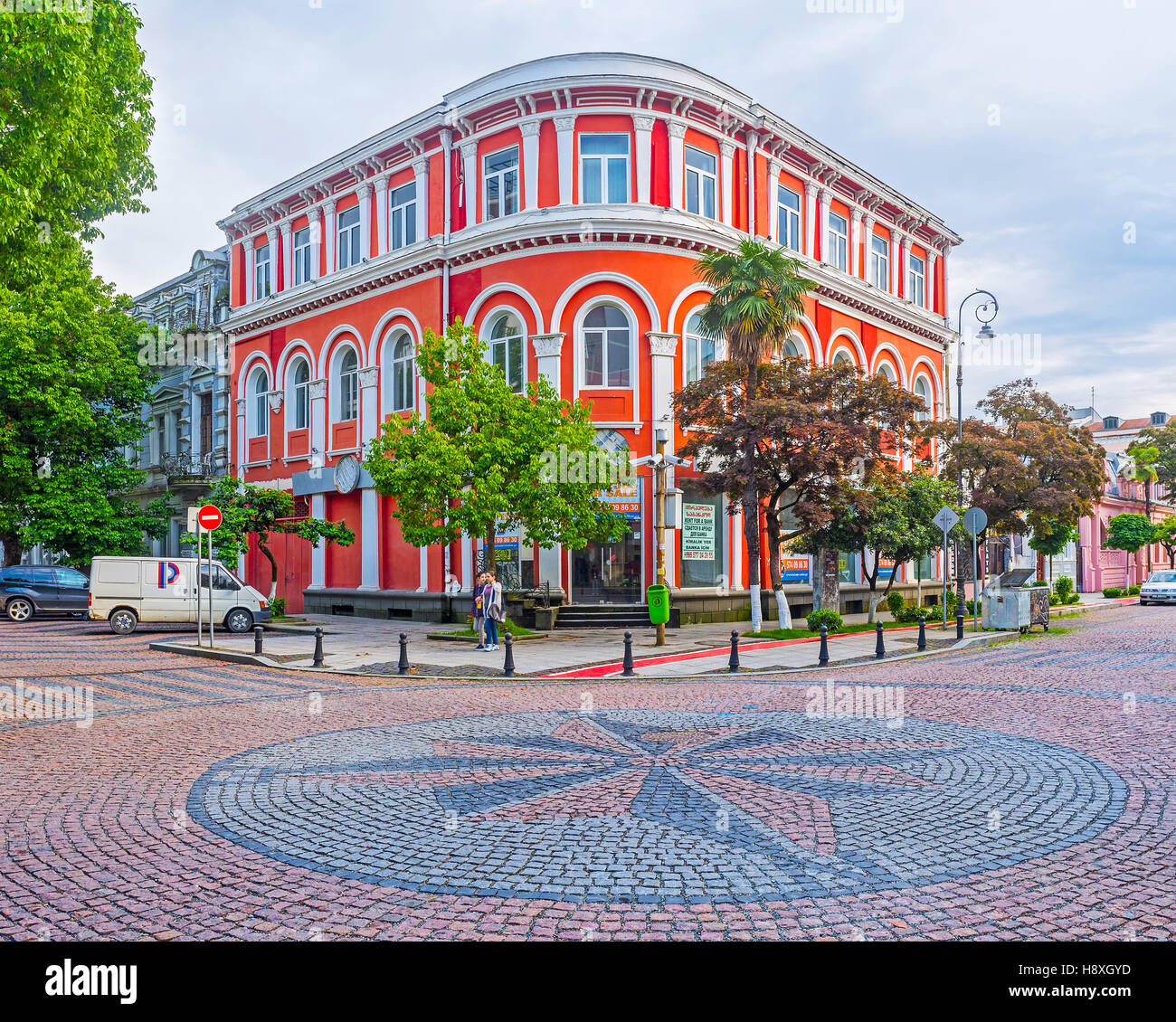 Il palazzo rosso nel quartiere turistico e la rosa dei venti della pavimentazione in pietra il bivio Foto Stock