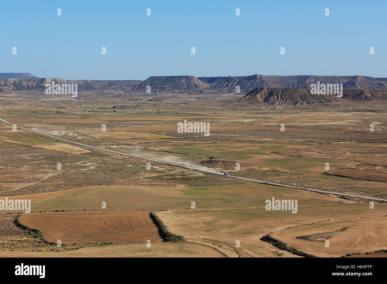 BARDENAS REALES, NAVARRA/SPAGNA - Agosto 16, 2014: un'auto drive su una strada di ghiaia attraverso Bardenas Reales parco naturale. Foto Stock