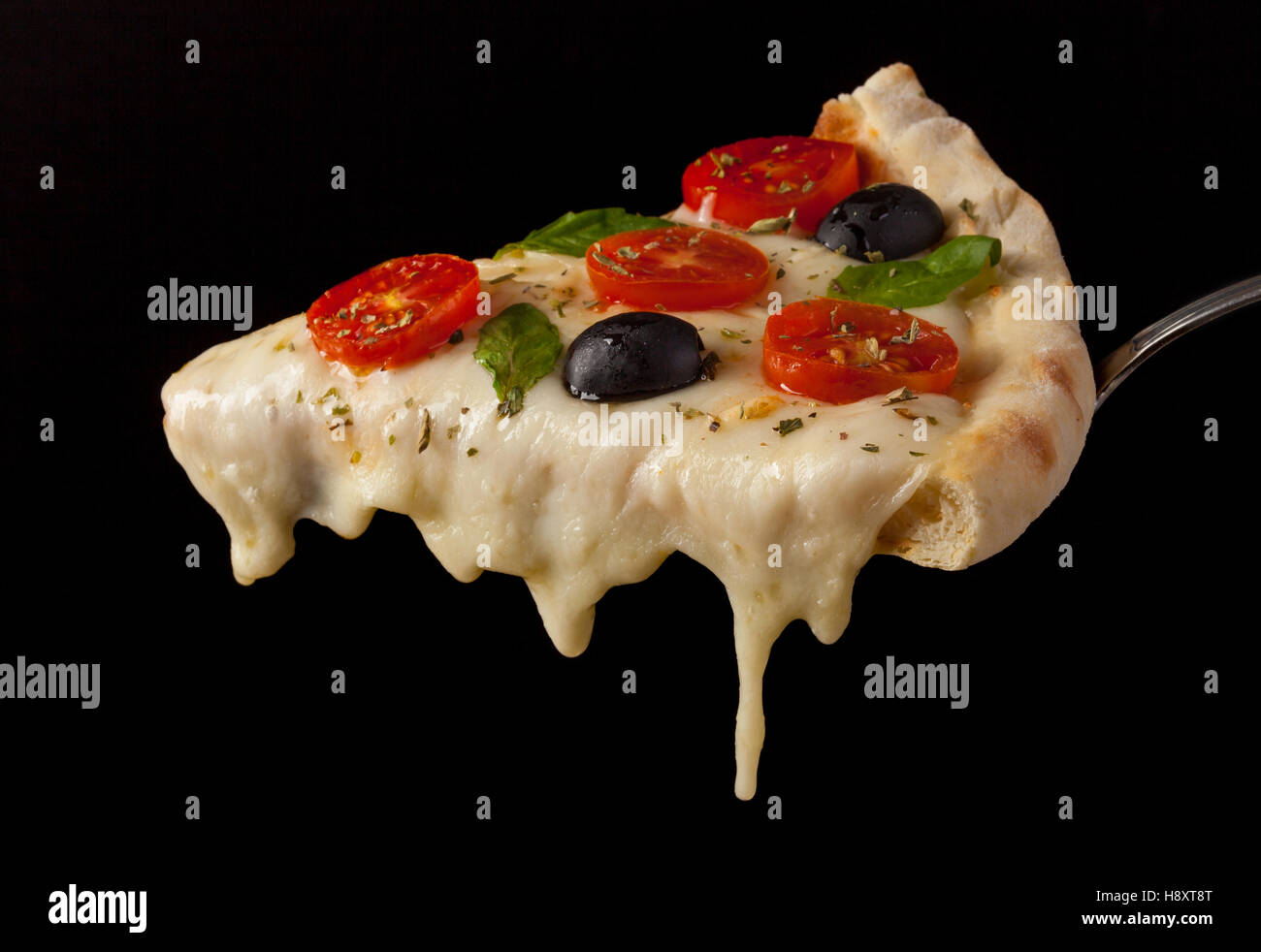 Un trancio di pizza caldo con sgocciolatura formaggio fuso. Isolato su nero. Foto Stock