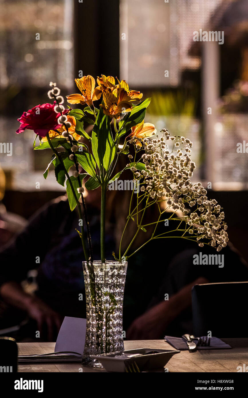 Un vaso di fiori su un ristorante tavolo. Foto Stock