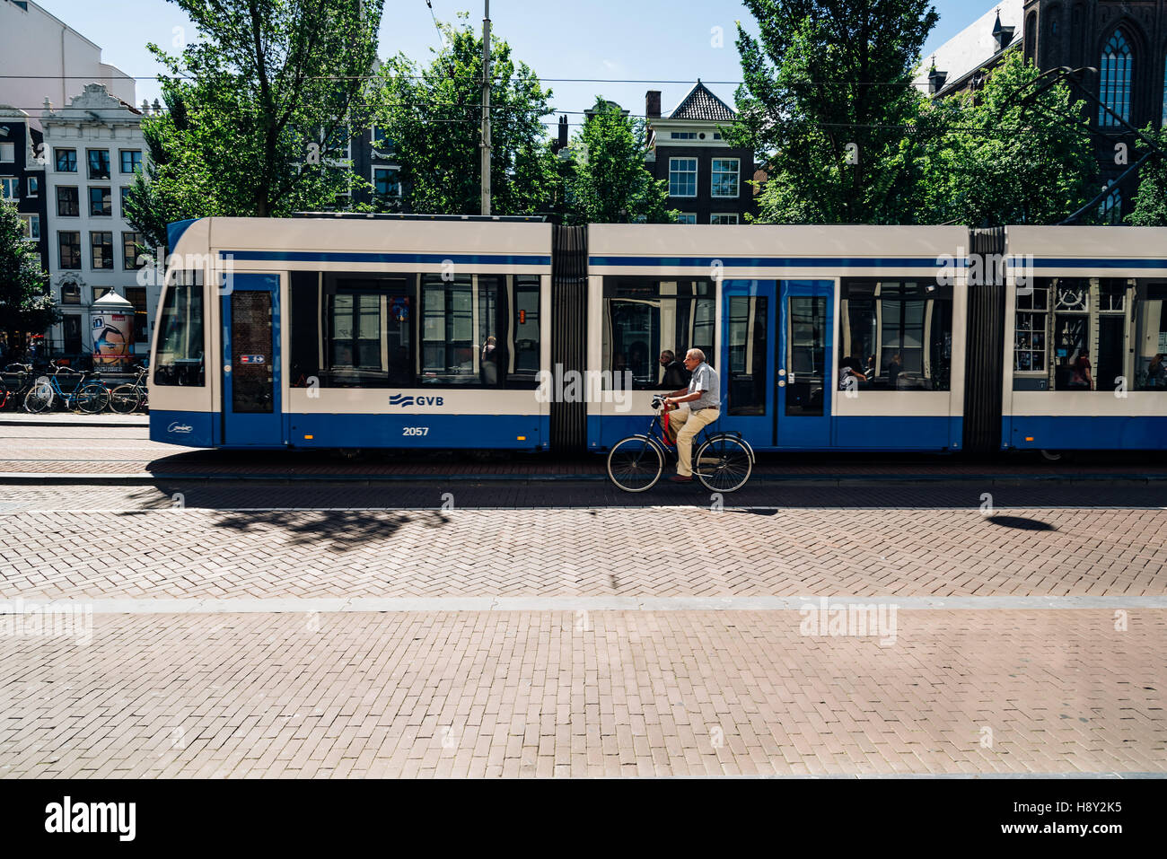 Amsterdam, Paesi Bassi - 1 agosto 2016: l'uomo in sella ad una bicicletta e tram in strada a Amsterdam. Foto Stock