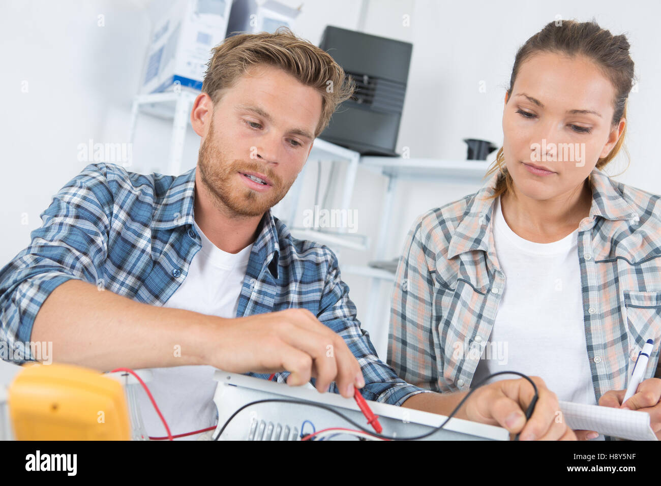 Uomo che fissa il computer con la donna a guardare Foto Stock