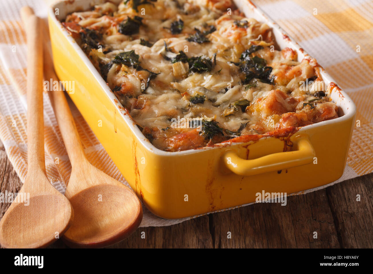 Gli strati casseruola con spinaci, formaggio e pane da vicino in un piatto per la cottura. Posizione orizzontale Foto Stock