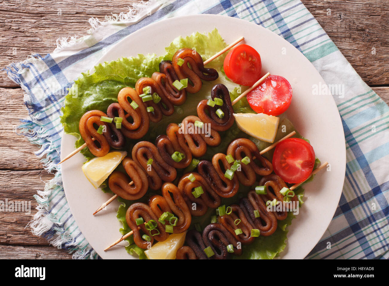 Calamari alla griglia su anelli di spiedini e verdure close-up su una  piastra sul tavolo. vista orizzontale dal di sopra Foto stock - Alamy