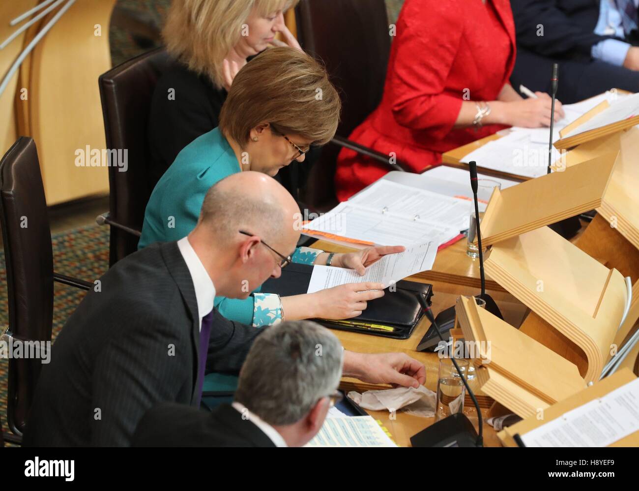 Nota: Sequenza immagine quattro di quattro Vice Primo Ministro John Swinney salviettine fino a un bicchiere di acqua versato come Primo Ministro Nicola Storione preparare per il primo ministro di domande presso il parlamento scozzese di Edimburgo. Foto Stock