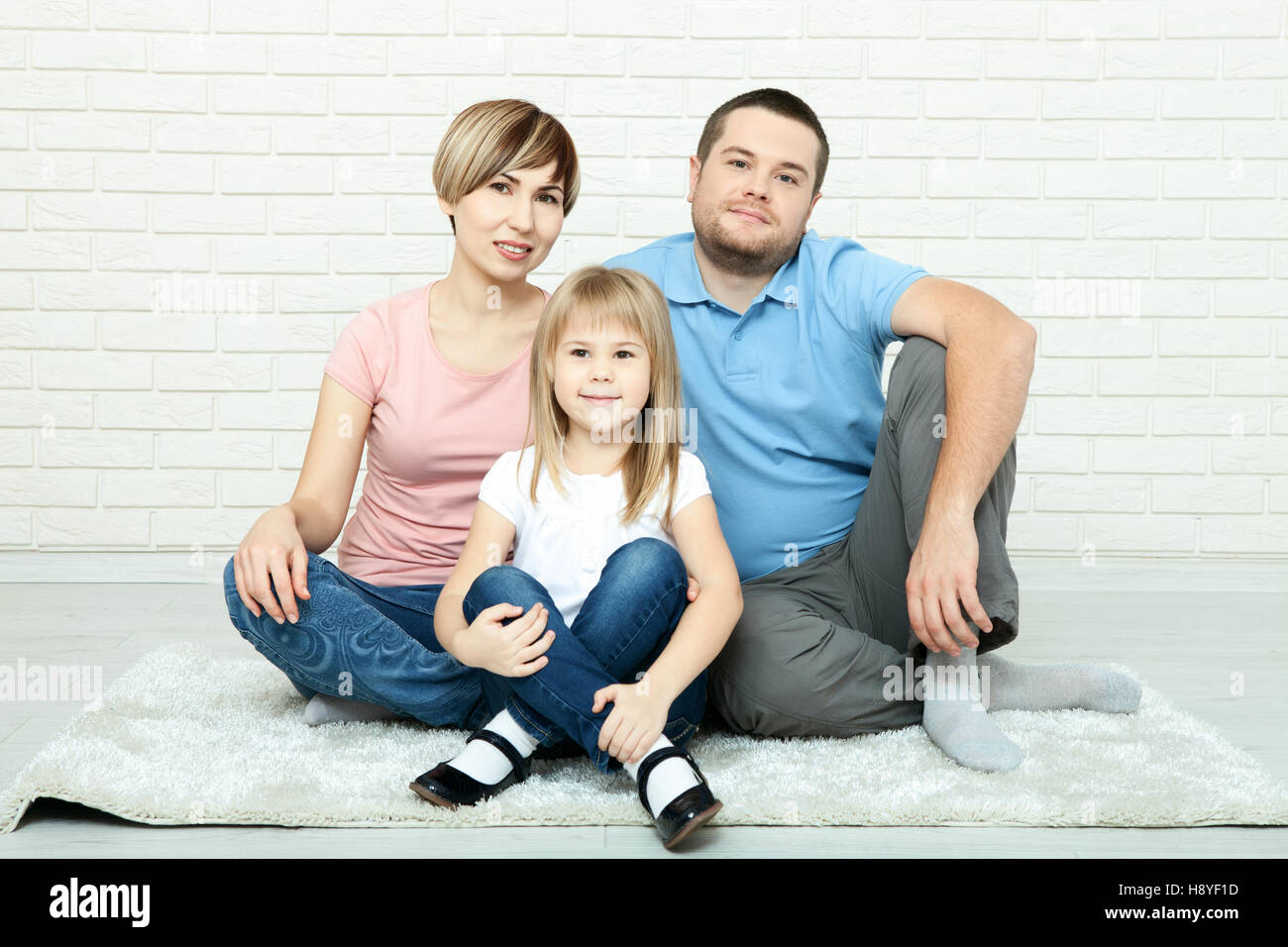 La famiglia felice la madre e il padre a giocare con il bambino a casa Foto Stock