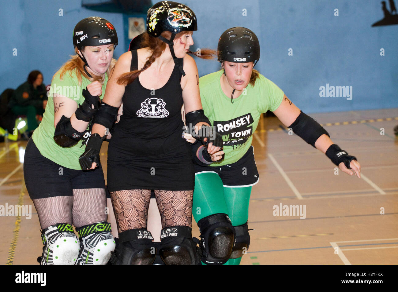 Tre donne roller derby skaters in contatto Foto Stock