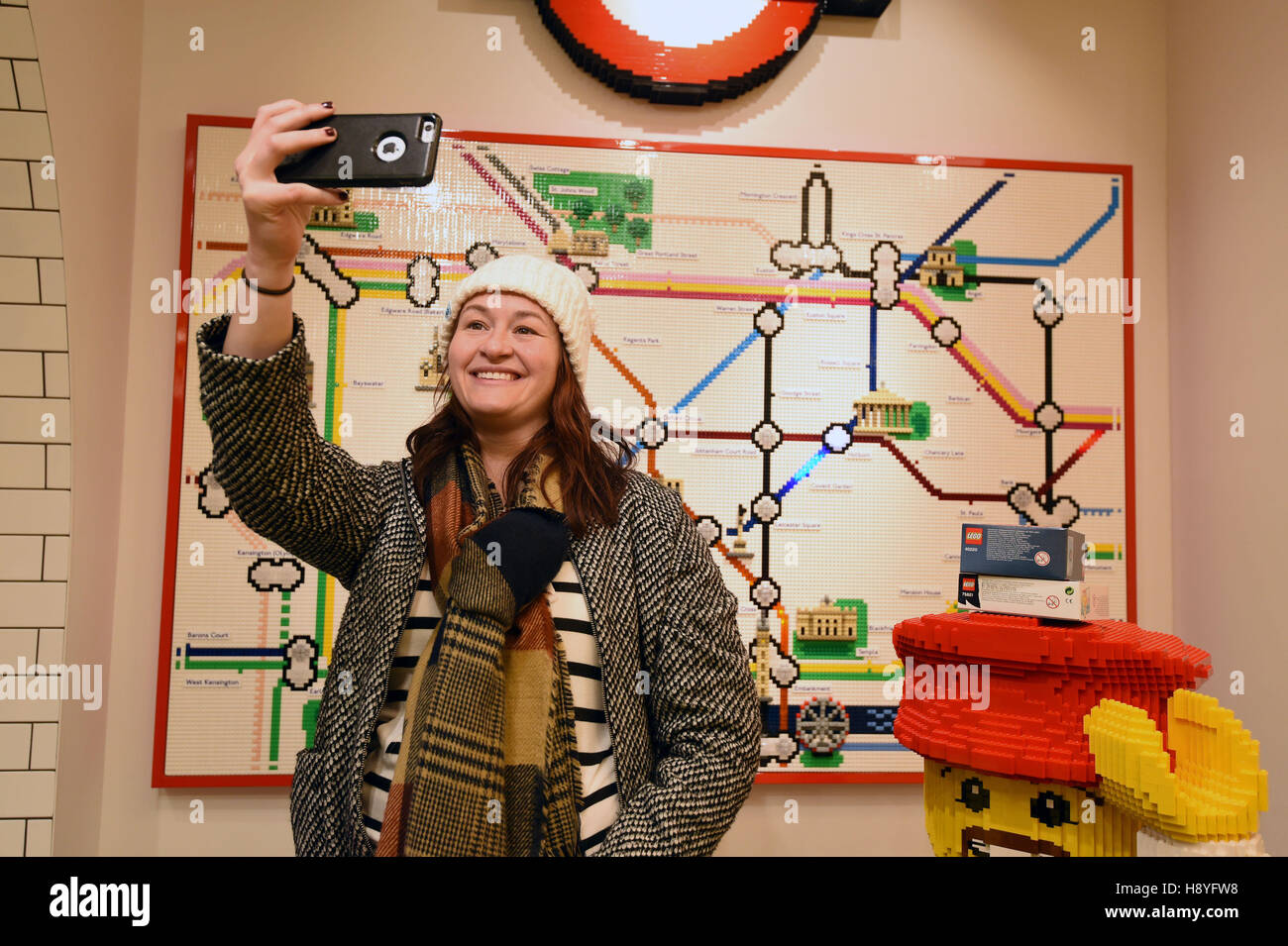 Una donna prende un selfie con una mappa tubo modello realizzato da Lego all'interno del 'più grande del mondo di LEGO store' nel quadrato di Leicester, Londra. Foto Stock