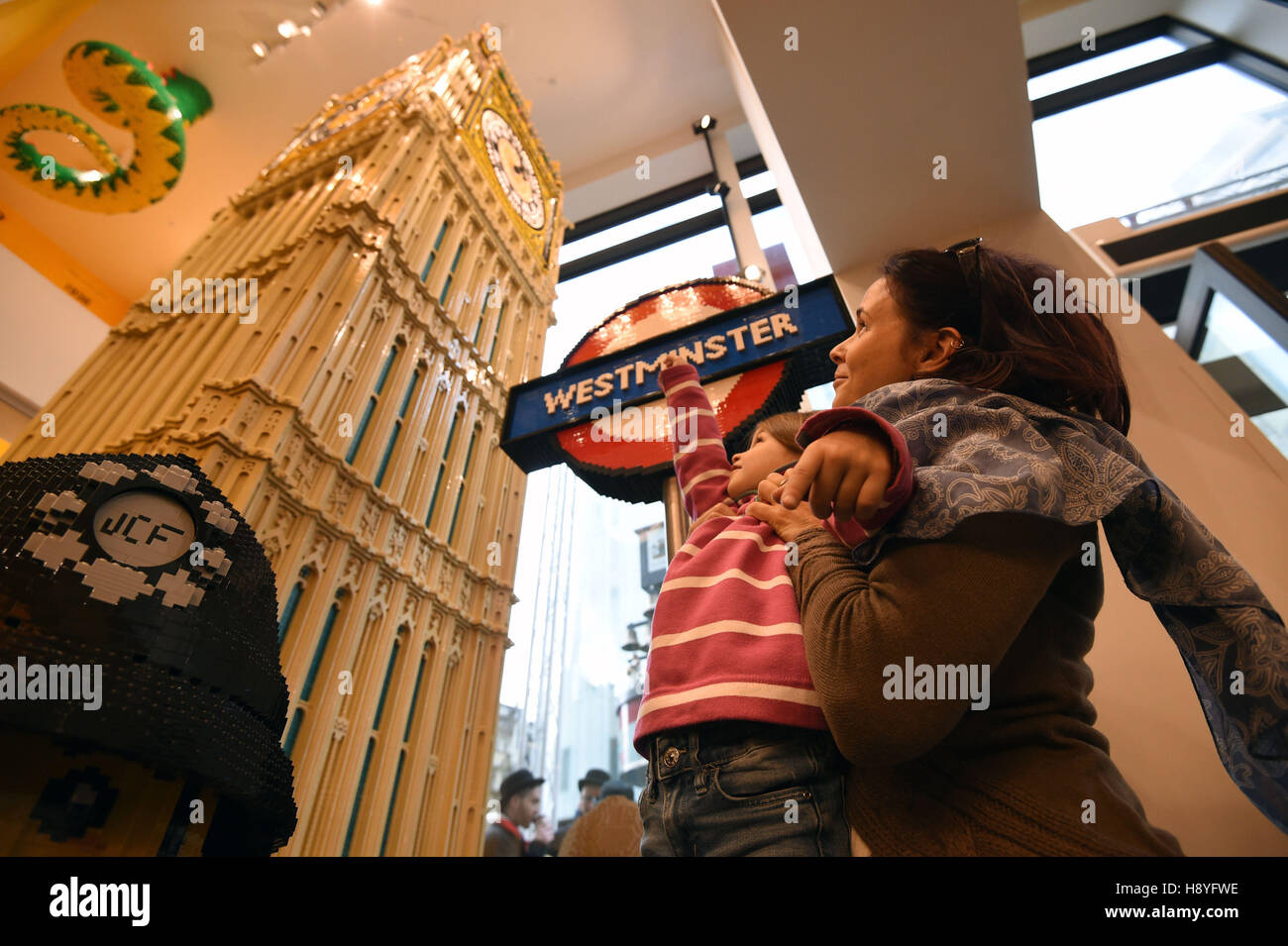 Molly (nessun dato di età) è mantenuto fino a vedere un modello di Lego di Big Ben all'interno della 'più grande del mondo di LEGO store' nel quadrato di Leicester, Londra. Foto Stock