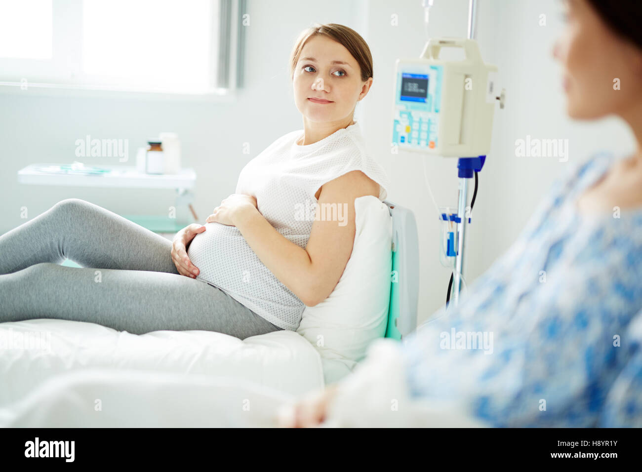 Donna incinta guardando un altro in ward durante il talk Foto Stock