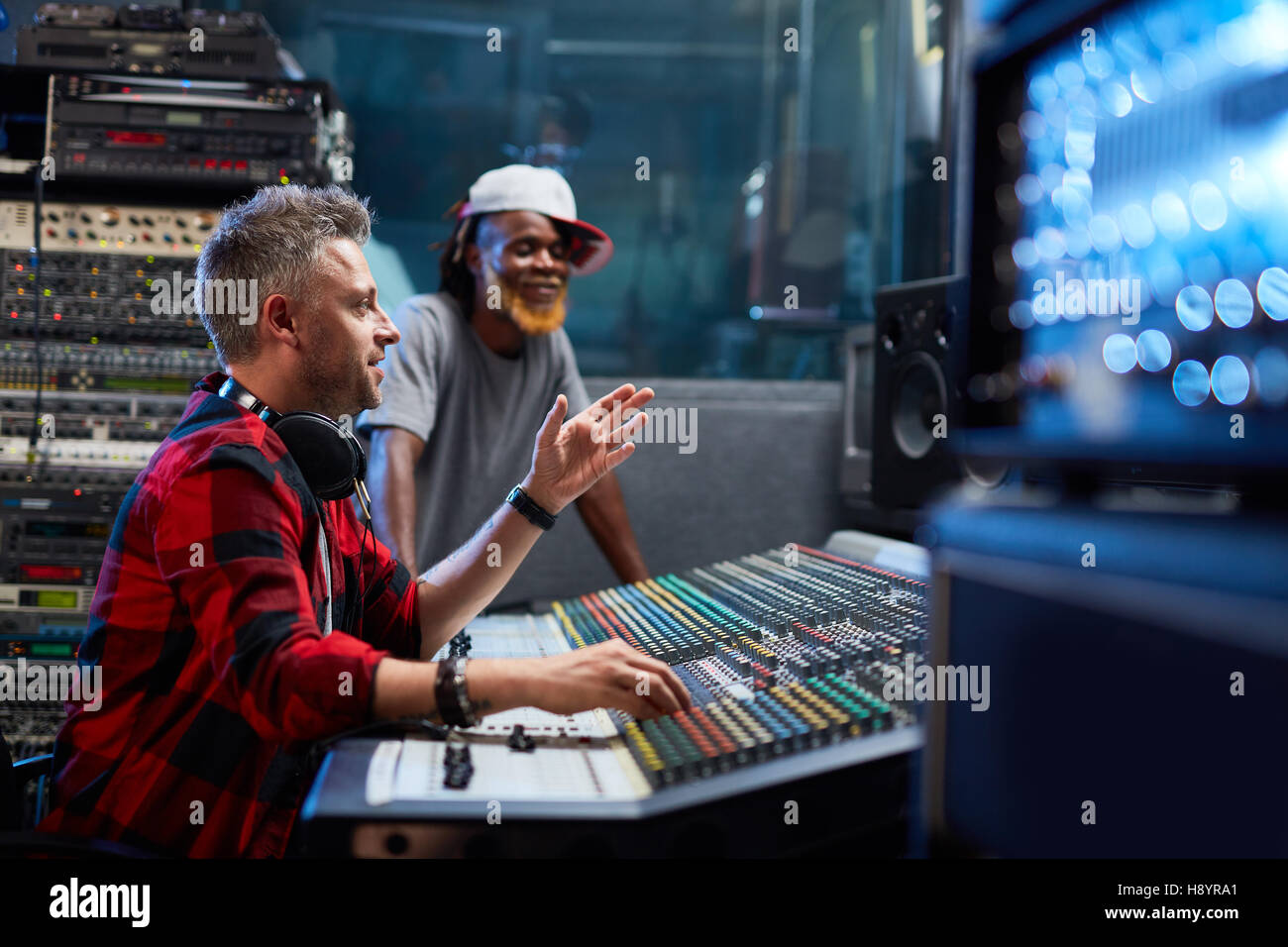 Sound-produttore rivolti a schermo mentre mostra il suo assistente del suono di livello Foto Stock